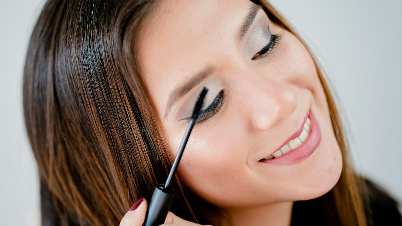 Profissional de beleza sorrindo enquanto atende uma cliente